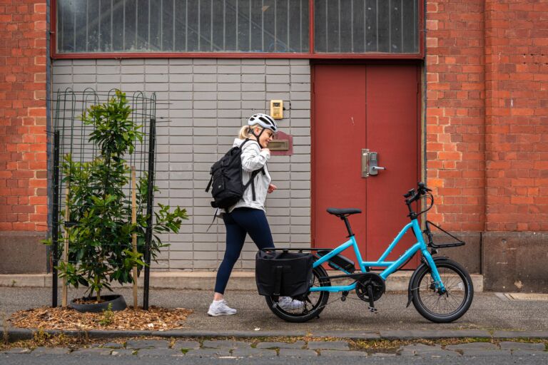 A woman standing next to her Tern Quick Haul electric bike, in brisbane