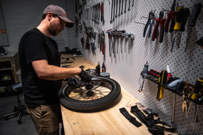 "Cam, a skilled mechanic at Melbourne Lug+Carrie workshop, expertly repairs a flat tire with precision and efficiency."